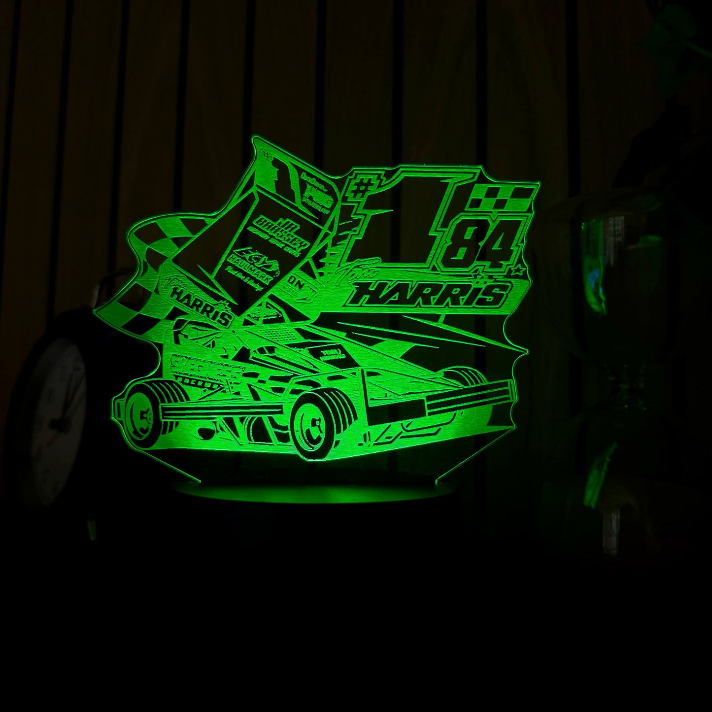 Glowing green race car design on a dark background TOM HARRSI STOCCAR MERHANDISE
