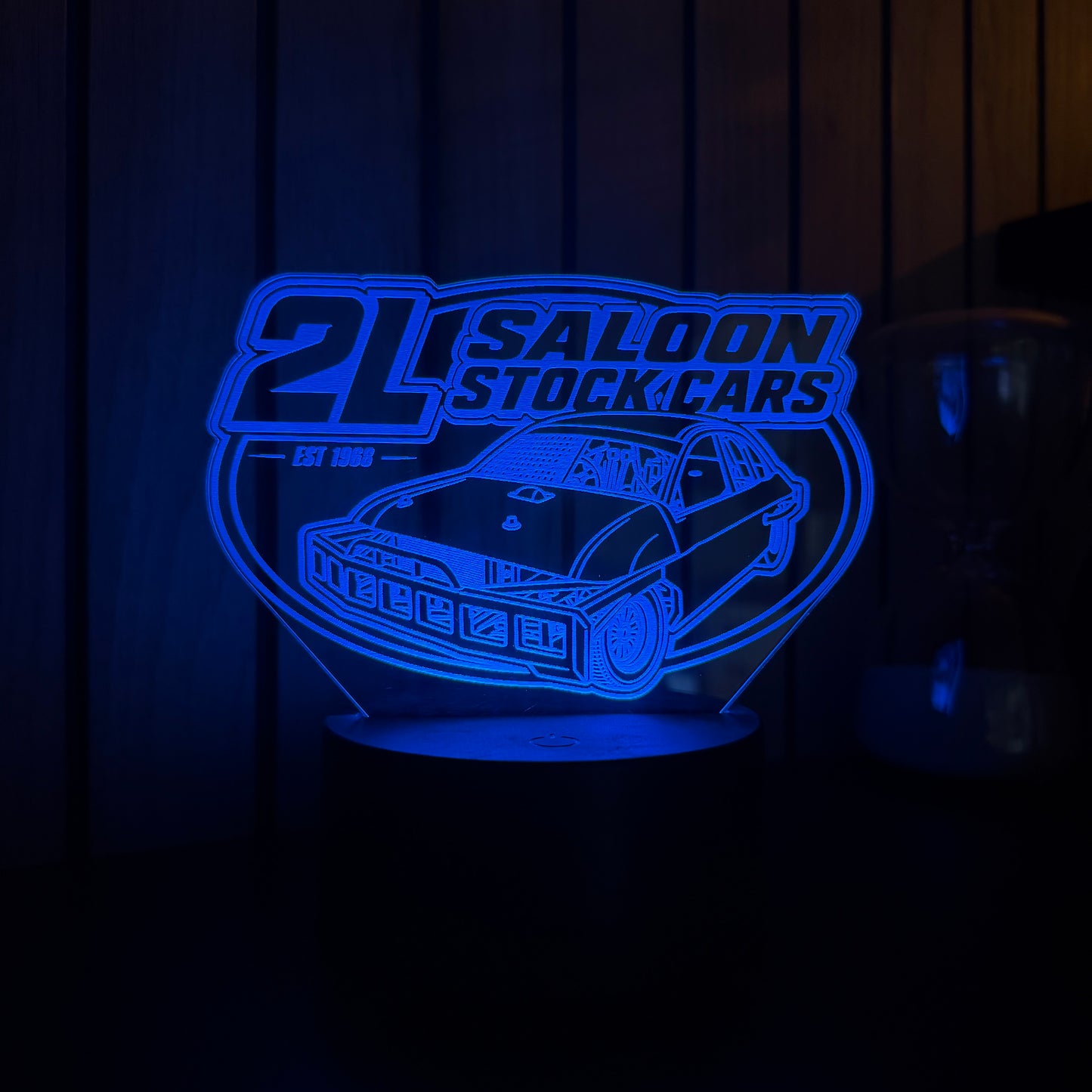 Blue illuminated sign with '2L Saloon Stock Cars' logo on a dark background