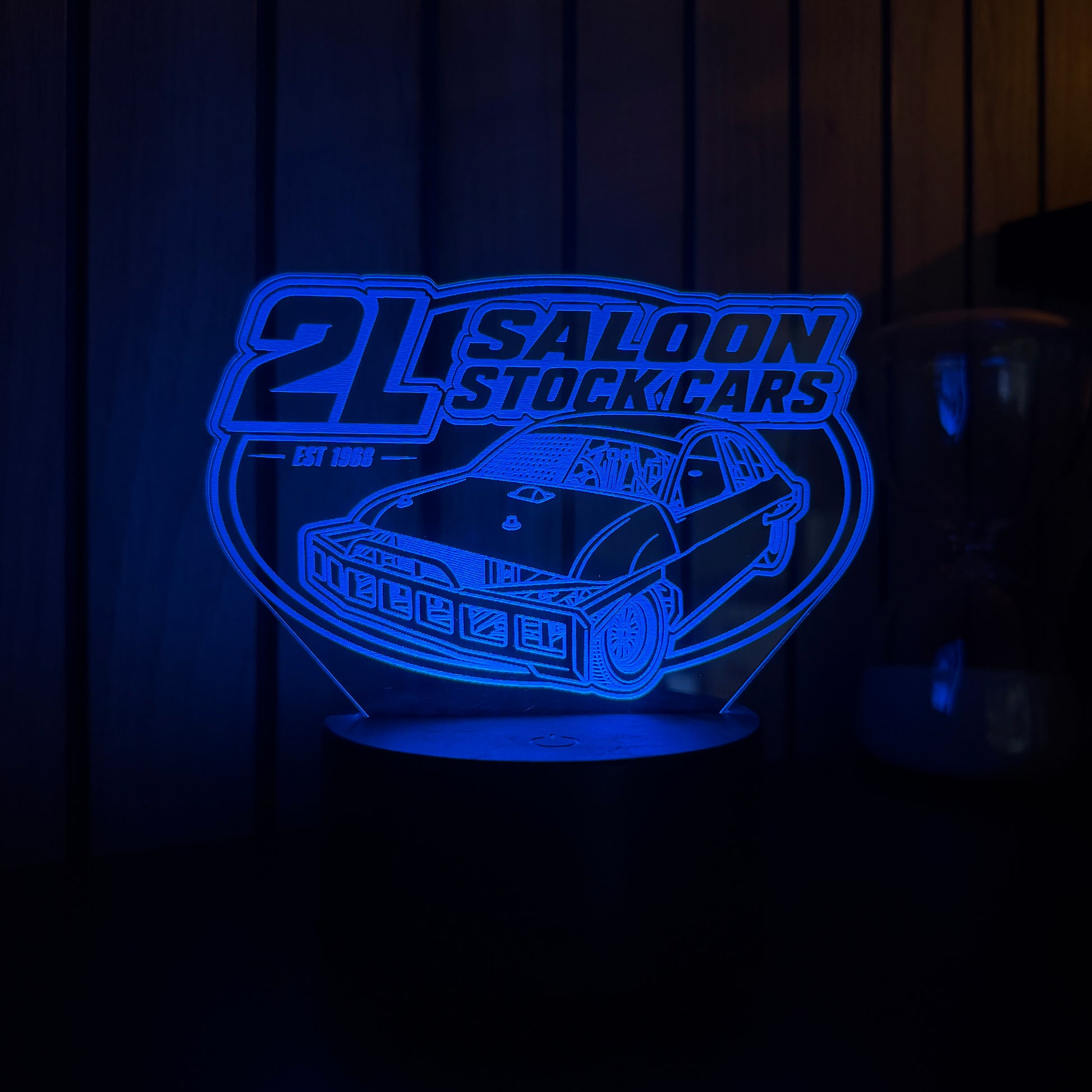 Blue illuminated sign with '2L Saloon Stock Cars' logo on a dark background